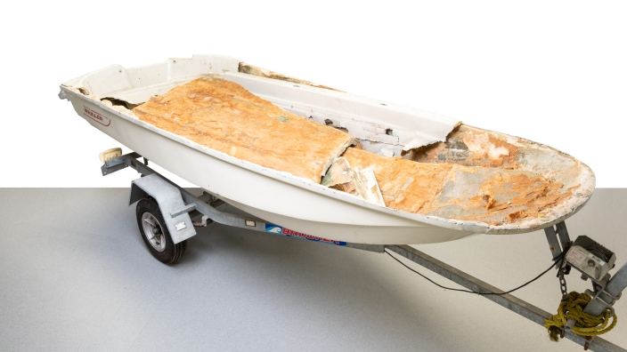 Fibreglass boat sliced open to reveal stacks of brown blocks