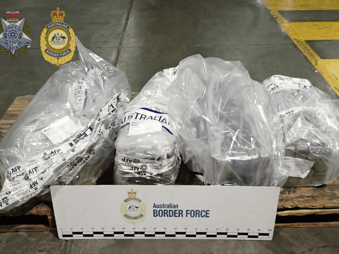 Four large plastic bags containing cocaine are sealed with AFP evidence tape.