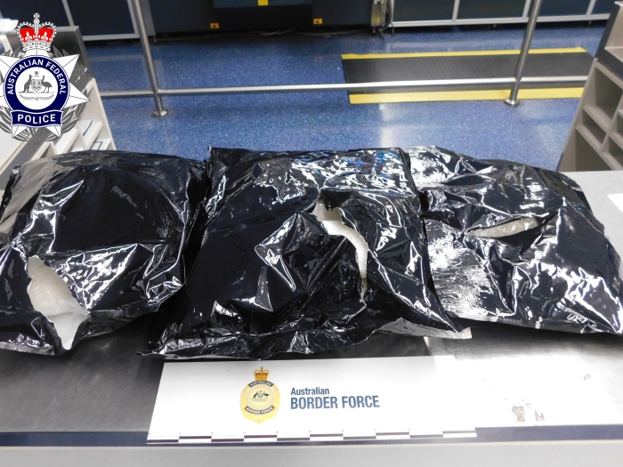 Three black plastic bags containing meth displayed on a counter