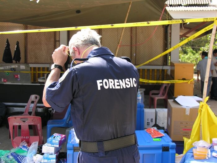 Forensics member taking photo at disaster scene
