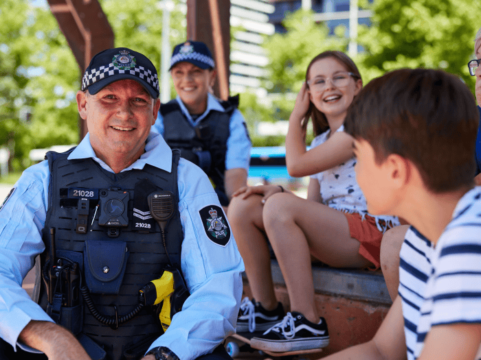 Two police officers talking to children outside