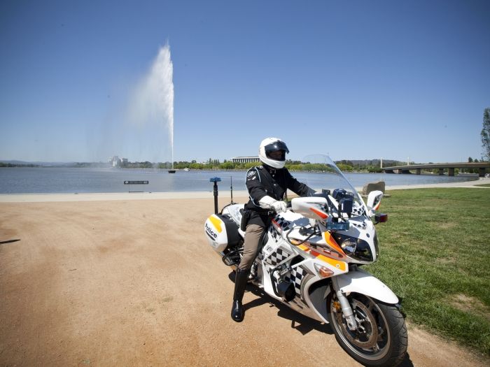 ACT Police Officer on a motorbike in front of the lake in Canberra