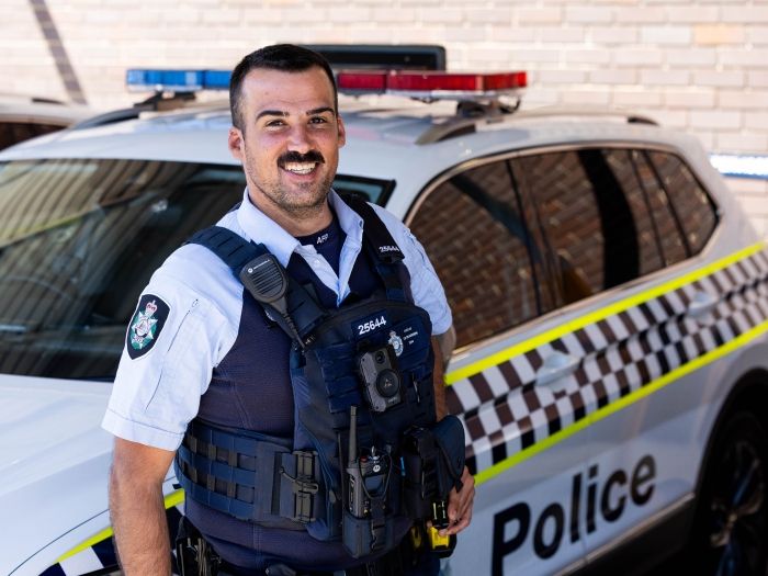 ACT Police Offier in front of a police vehicle