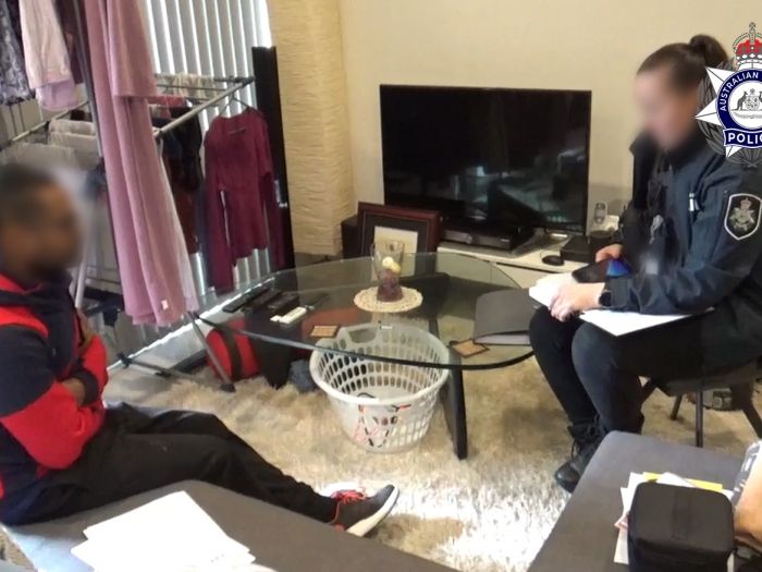 Image of the man jailed being interviewed by an AFP officer inside his home