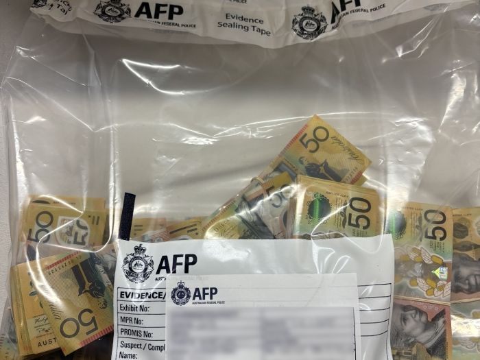 Image of a large amount of $50 notes in an AFP evidence bag