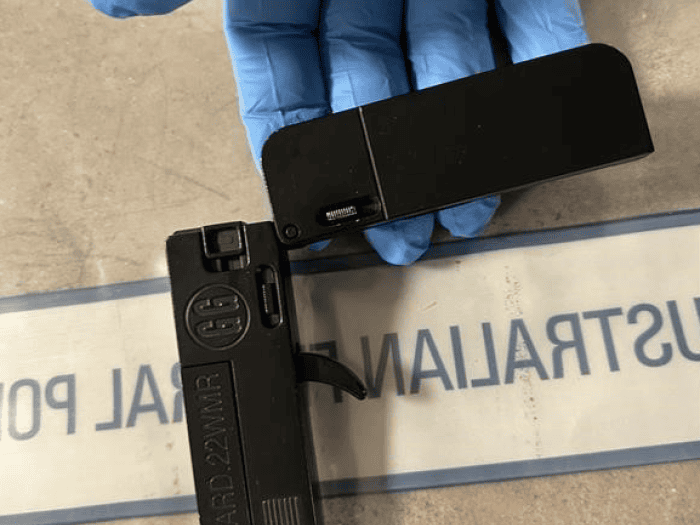 A mini pistol held in the hand of an AFP investigator after it was found in his luggage and seized at Perth Airport 