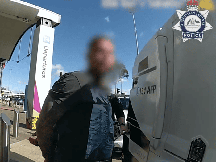 WA man charged at Perth Airport, waiting to be placed into AFP vehicle