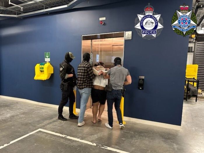 A man is arrested and escorted by police. 