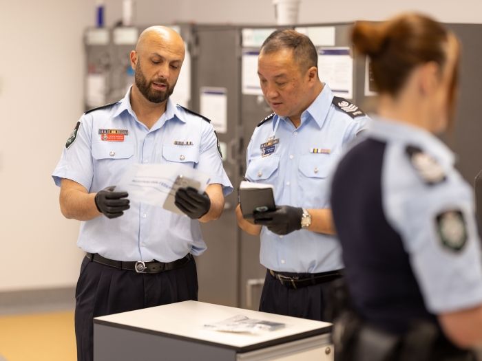 Three officers in a room with two reviewing evidence