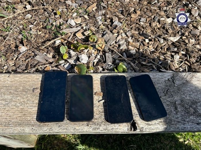 Four phones lined up on an outside pillar