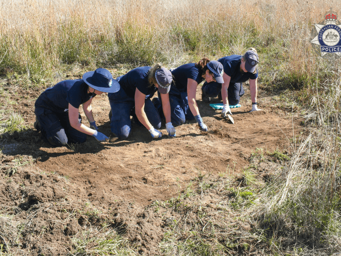 Forensics members digging at burial site