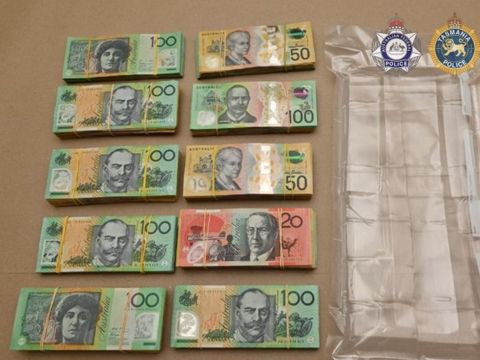 Bundles of cash laid out on a table. Includes $100 bills, $50 bills and $20 bills. 