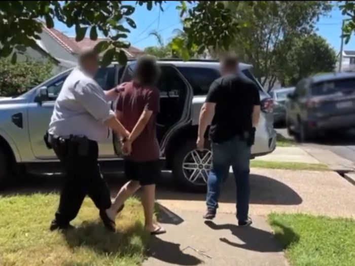 This overt activity resulted in the arrest of a 21-year-old Queensland man after AFP officers executed a search warrant at a Brisbane home on Thursday (4 December, 2025) following the importation of a significant quantity of flags and literature. 