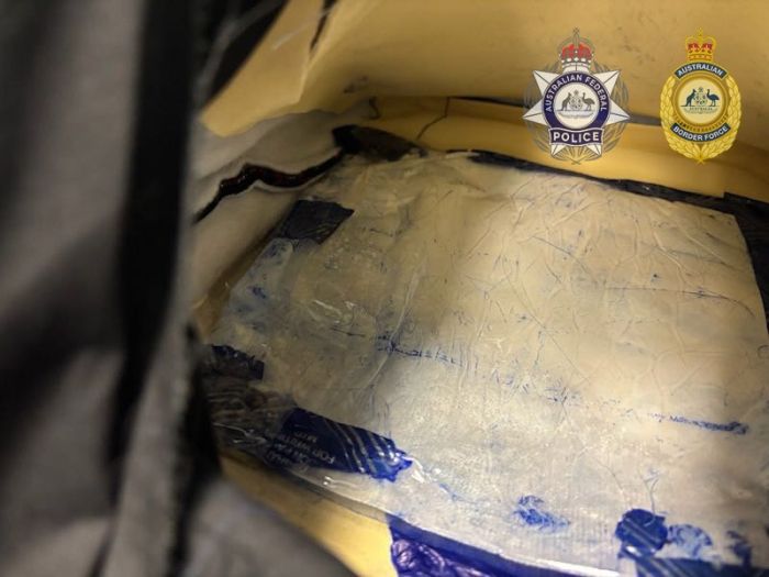 Photo shows a brick of cocaine hidden inside a suitcase