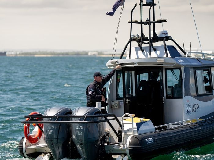 A police boat on the water with an armed officer on board