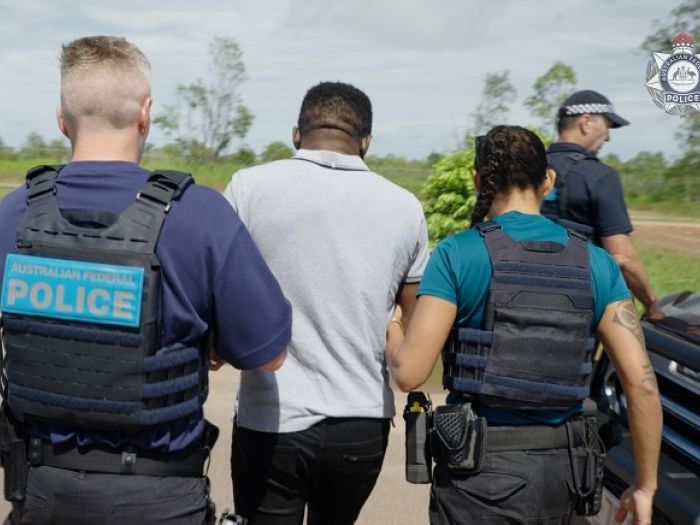 Man escorted by three AFP officers. 