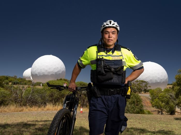 Photograph of an Australian Federal Police Protective Service Officer on a bike conducting patrols.