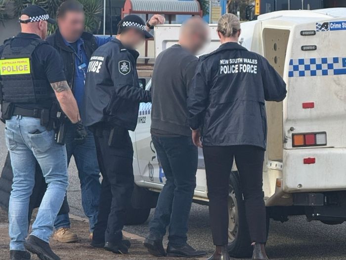 Arrested man being escorted to police vehicle