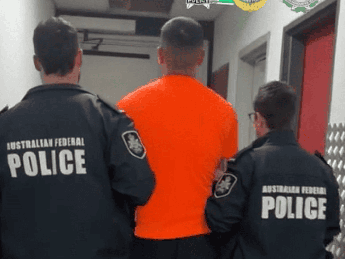 A man is arrested by two AFP members
