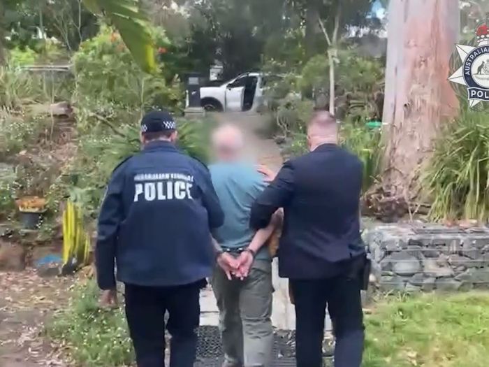 Northern Sydney man in handcuffs being escorted by AFP officers 