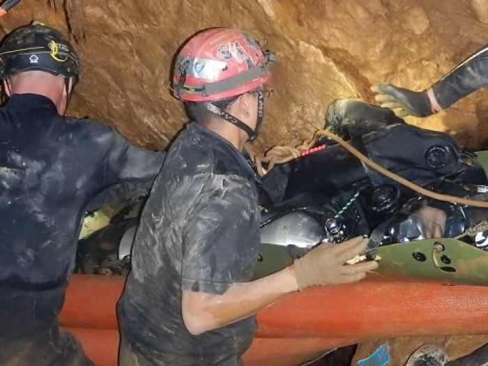 One of the boys in a  sked  (the green flexible stretcher) being moved through one of the last three chambers.JPG