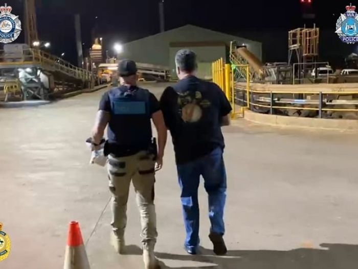 A man is escorted by an AFP officer