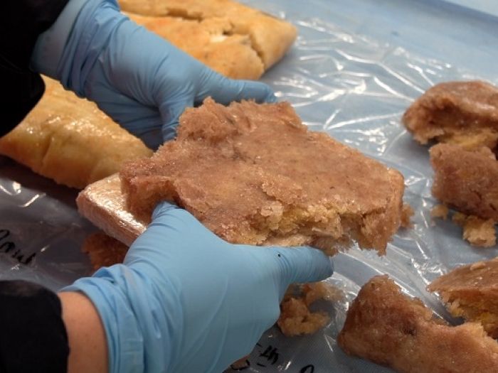 An officer inspects the consignment of cocaine secreted in the bags of banana pulp 