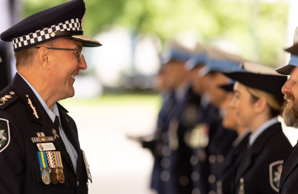 A line of police officers being greeted by a senior officer