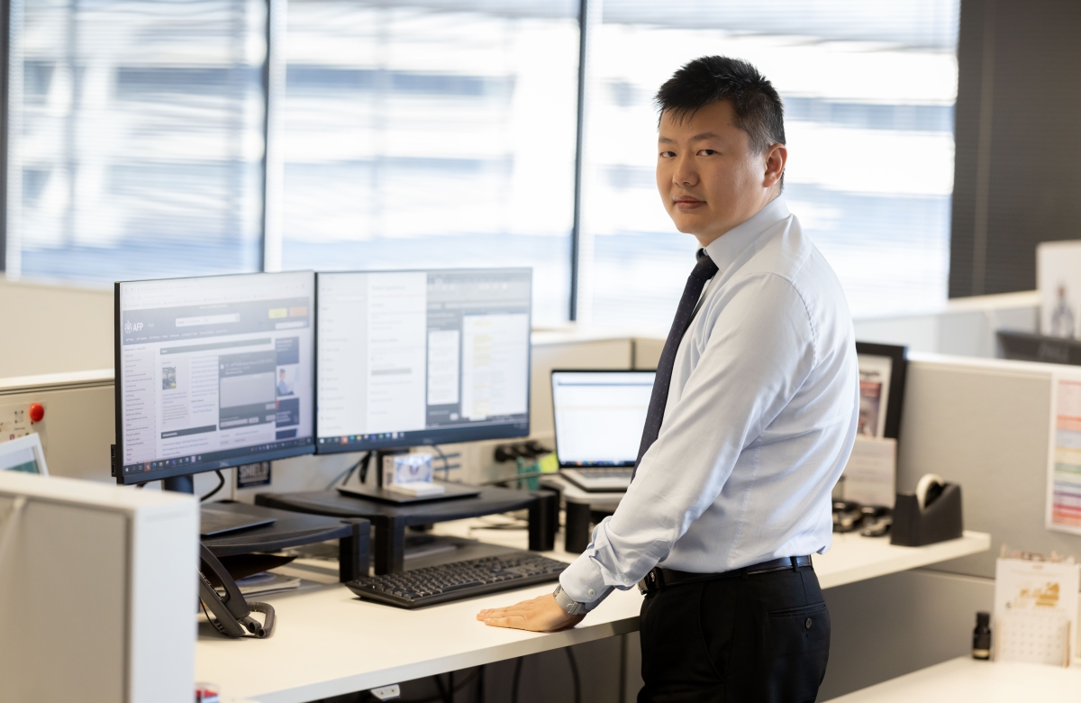 Man in a suit at a standing office desk