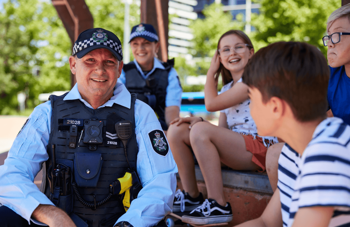 Two police officers talking to children outside