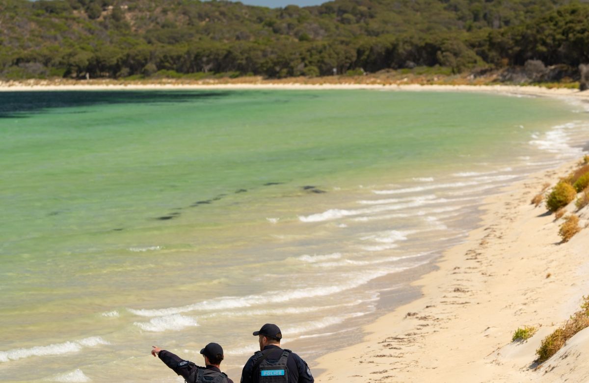 Two police officers walking along a beach in WA
