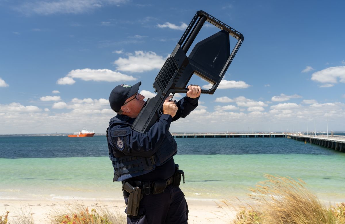 AFP Protective Service Officer using a drone detector with the ocean in the background