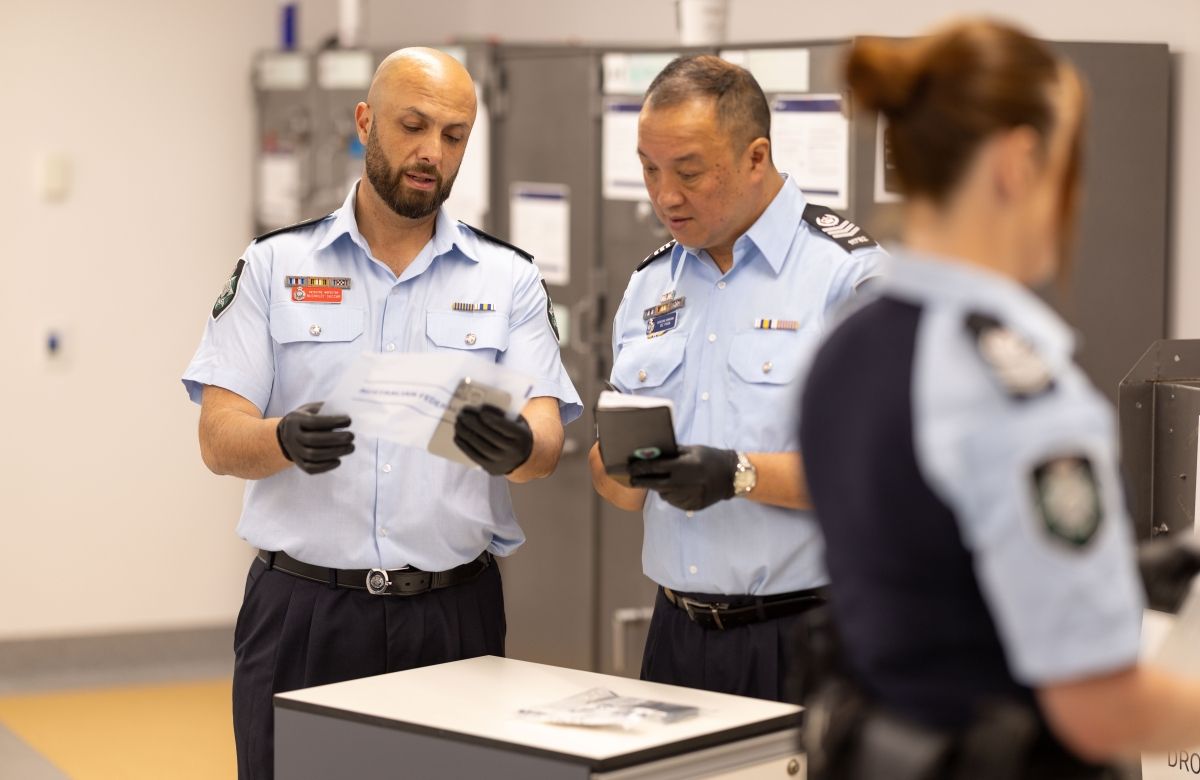 Three officers in a room with two reviewing evidence