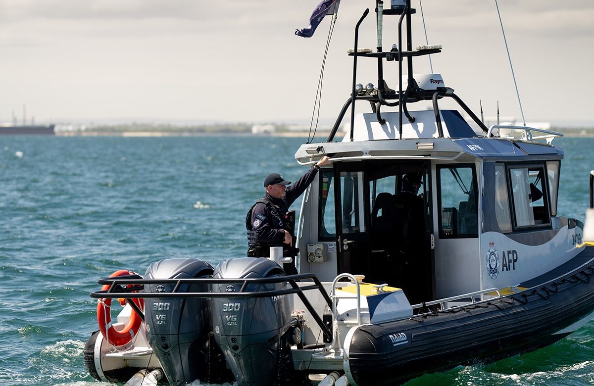 A police boat in the water with an armed officer aboard