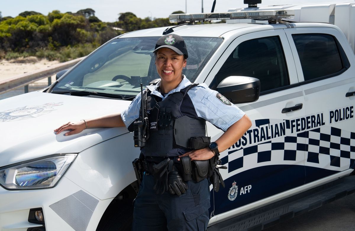 Female officer in front of AFP vehicle