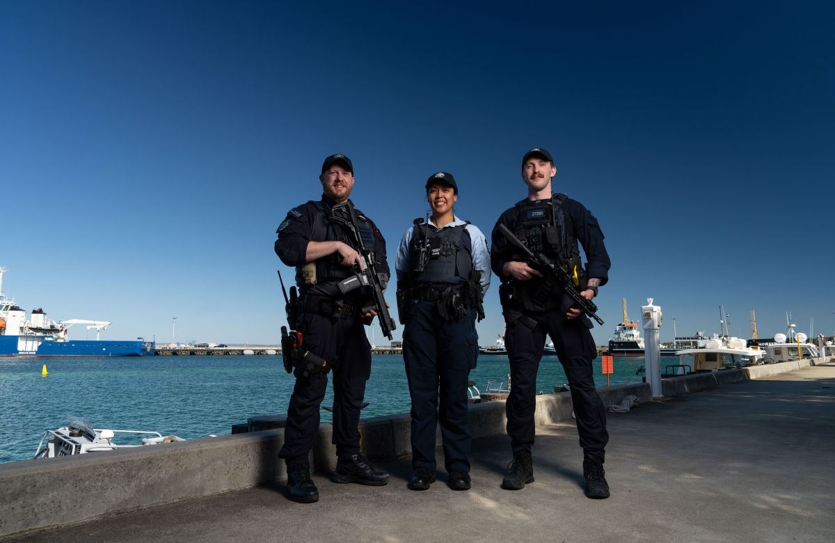Three Protective Service Officers on a wharf with water behind them