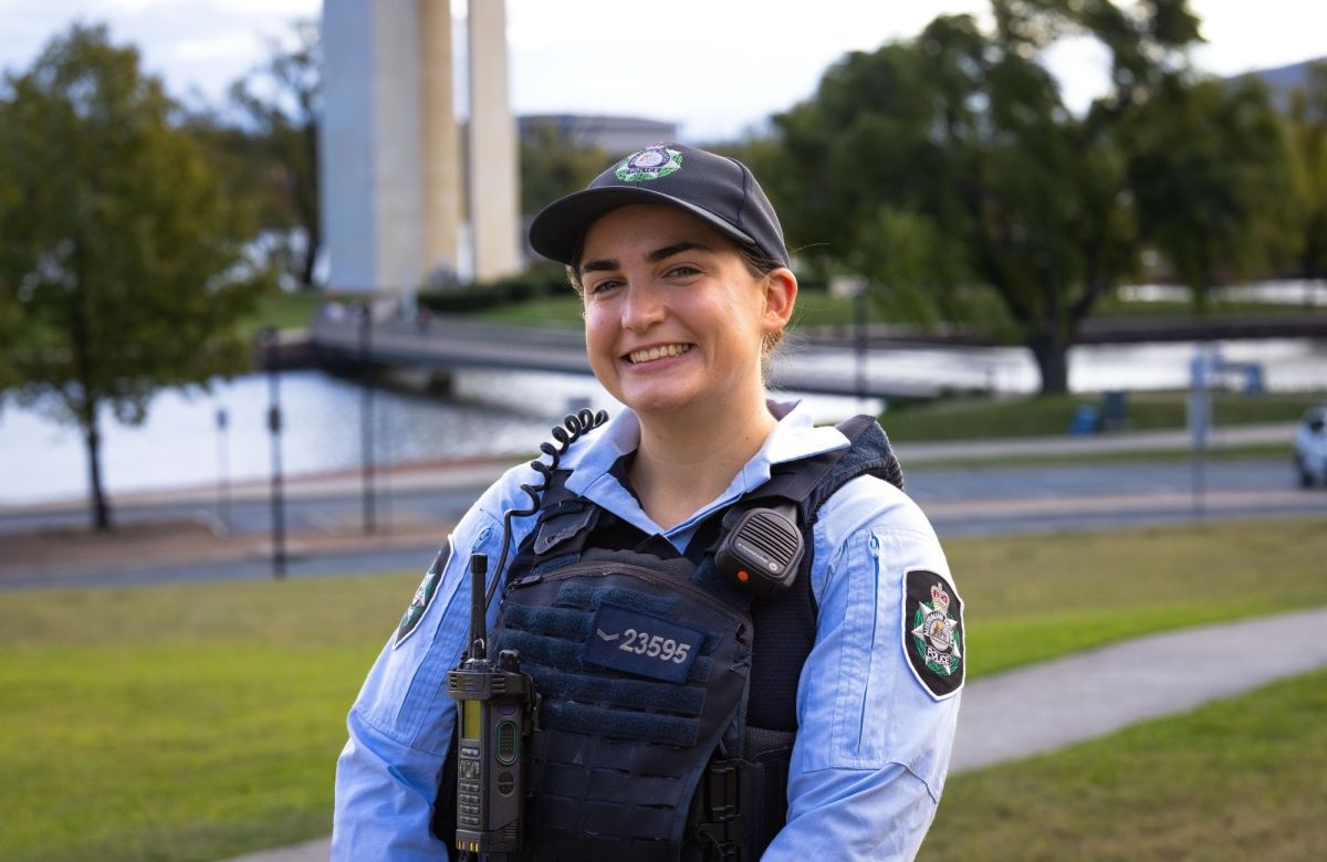 AFP Officer in a blue uniform standing outdoors near a waterfront.