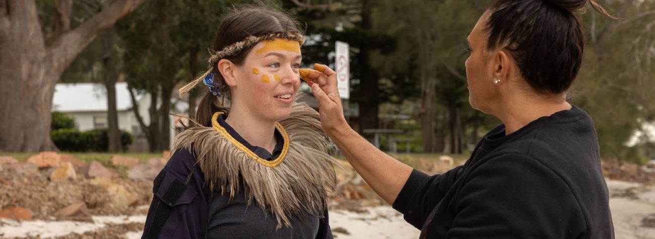 Two first nations women preparing cultural face paint