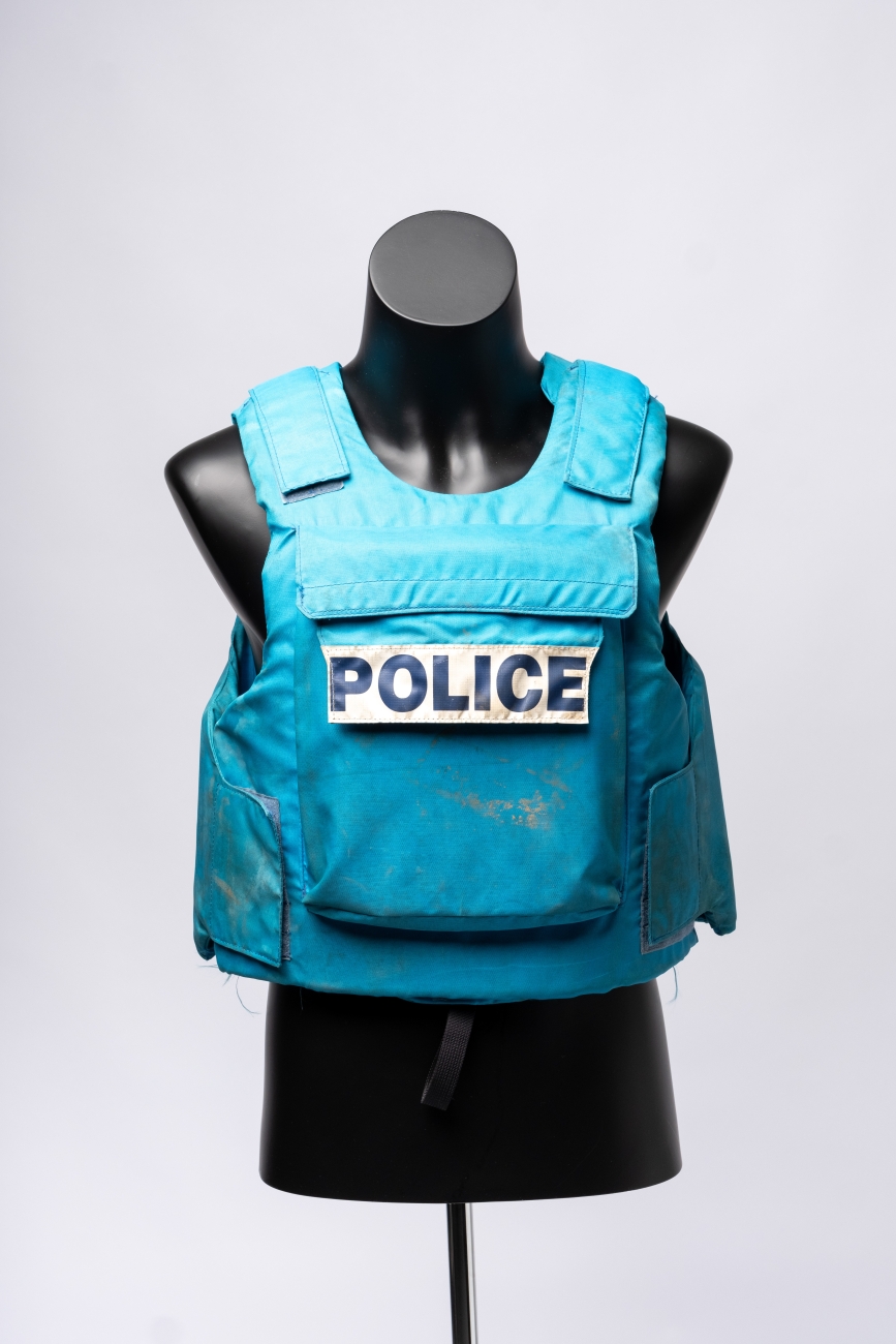 Blue woven fabric padded vest with front pocket and large white label that reads 'POLICE' in large black block letters (AFPM8869)