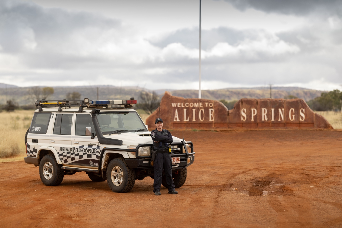 AFP PSO Officer with four wheel drive and Alice Springs sign in the background