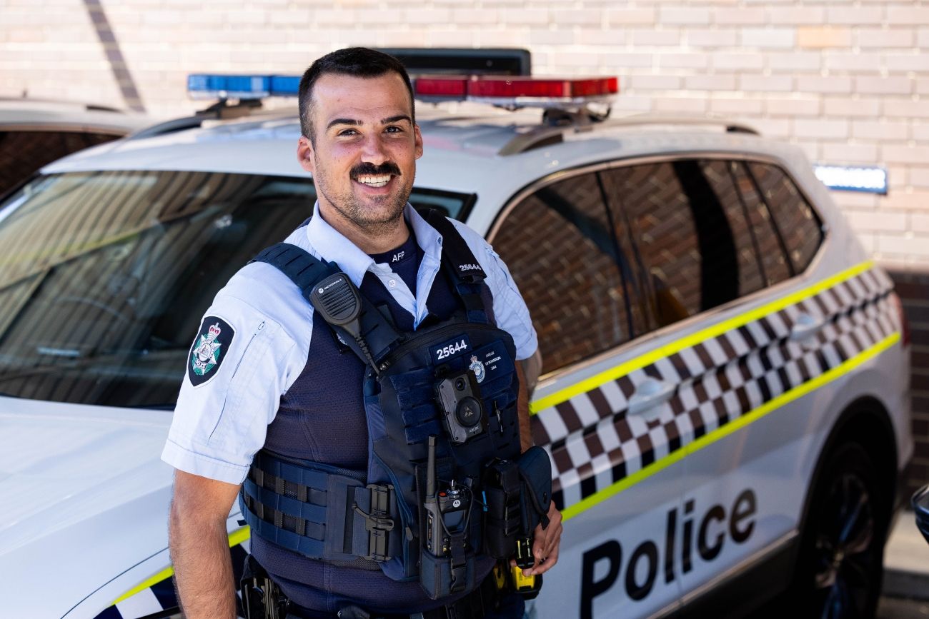 ACT Police Offier in front of a police vehicle