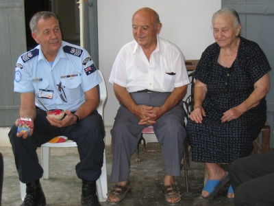 An Australian police peacekeeper sharing some food with a Greek Cypriot couple, in northern Cyprus. The UN retains responsibility to check on the welfare of minority communities across the island