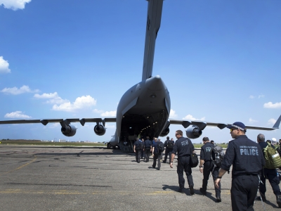 A group of Australian police officers walking across an airport tarmac toward an aeroplane