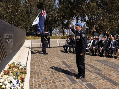 AFP Commissioner Reece P Kershaw saluting at the 60 Years of police peacekeeping memorial service at the National Peacekeepers Memorial in Canberra.